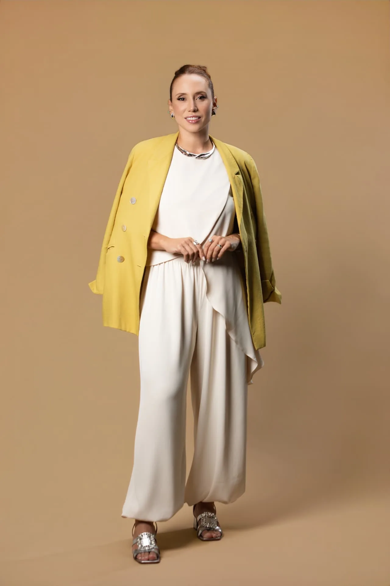 Milena Costa em look off-white com blazer amarelo, corpo inteiro